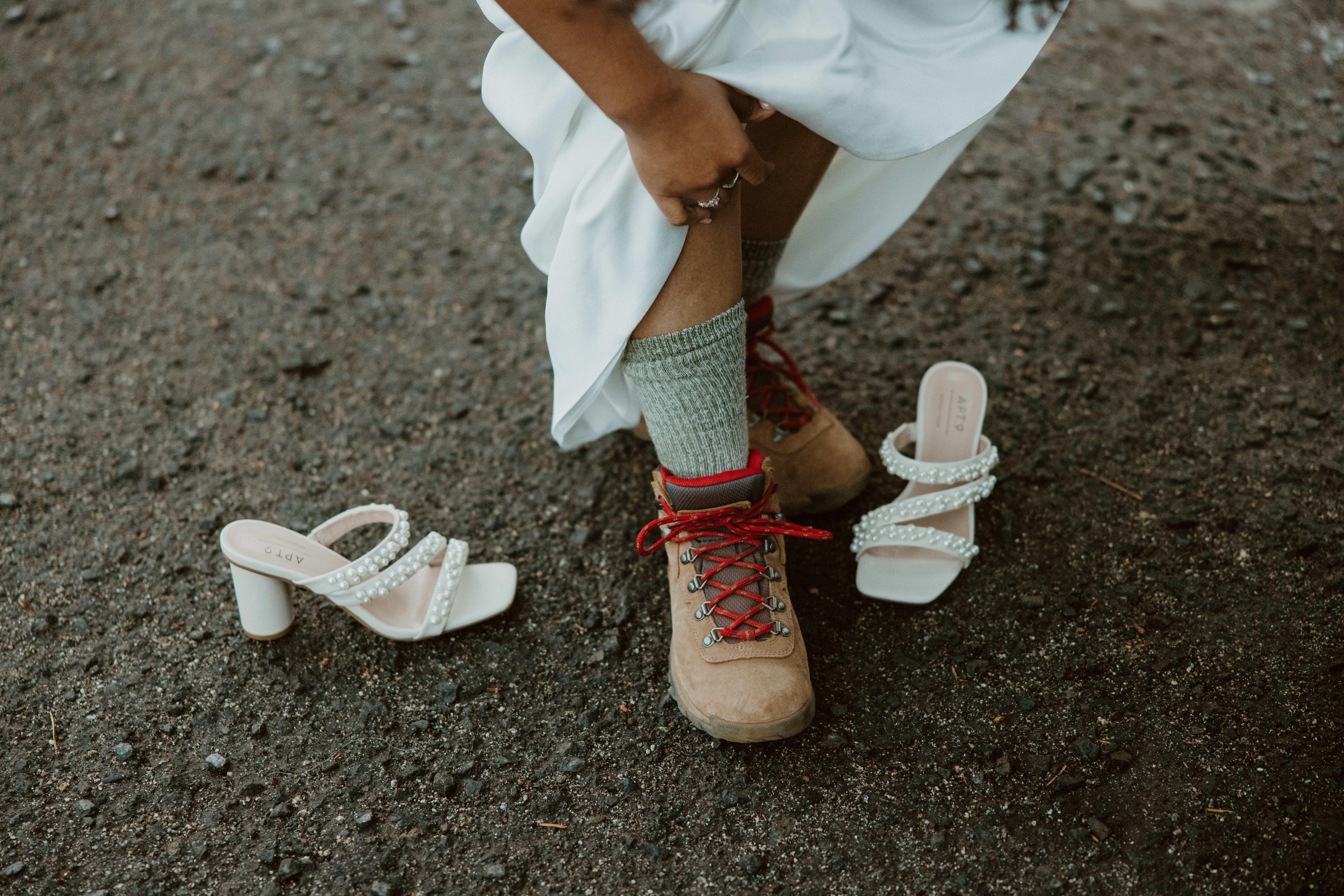 bride putting hiking shoes on after ceremony